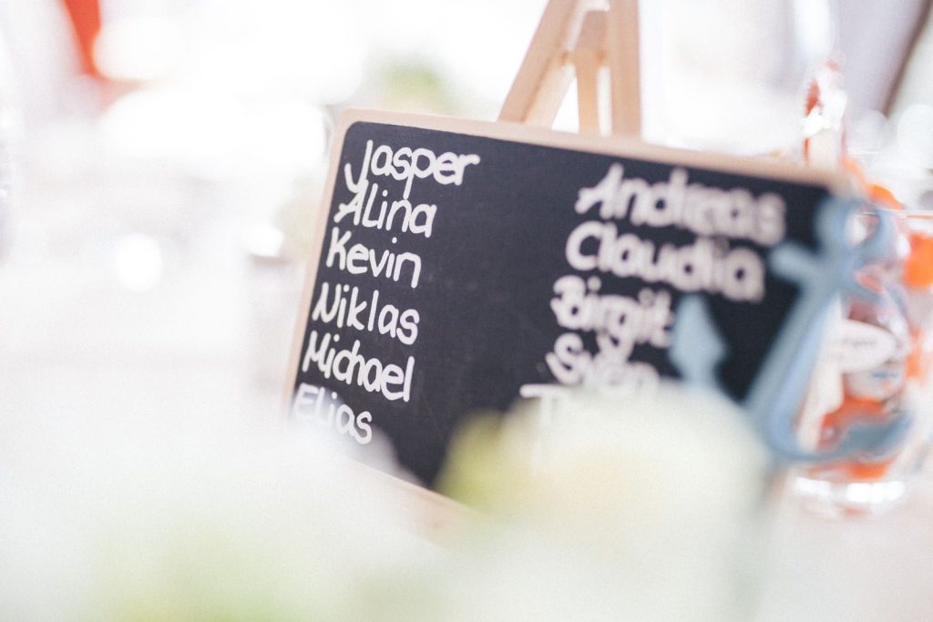 A decorative chalkboard displaying names at a refined indoor gathering.