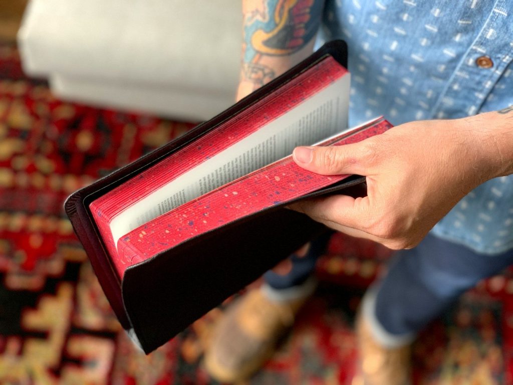 person holding red and white box
