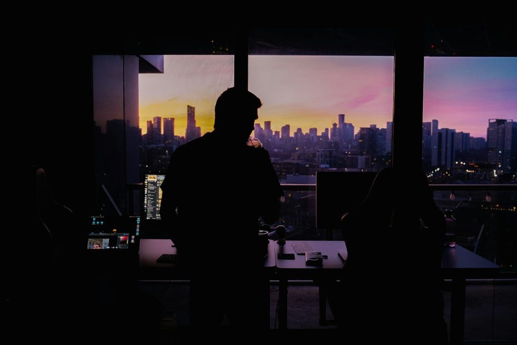 A couple of people standing in front of a window